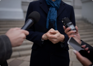 אדם מדבר אל מקירופונים של עיתונאים